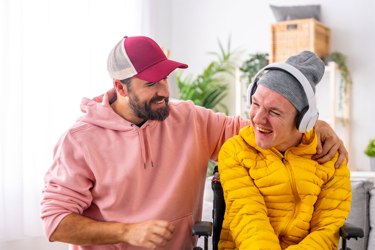 Man supporting another with arm over shoulders whilst smiling