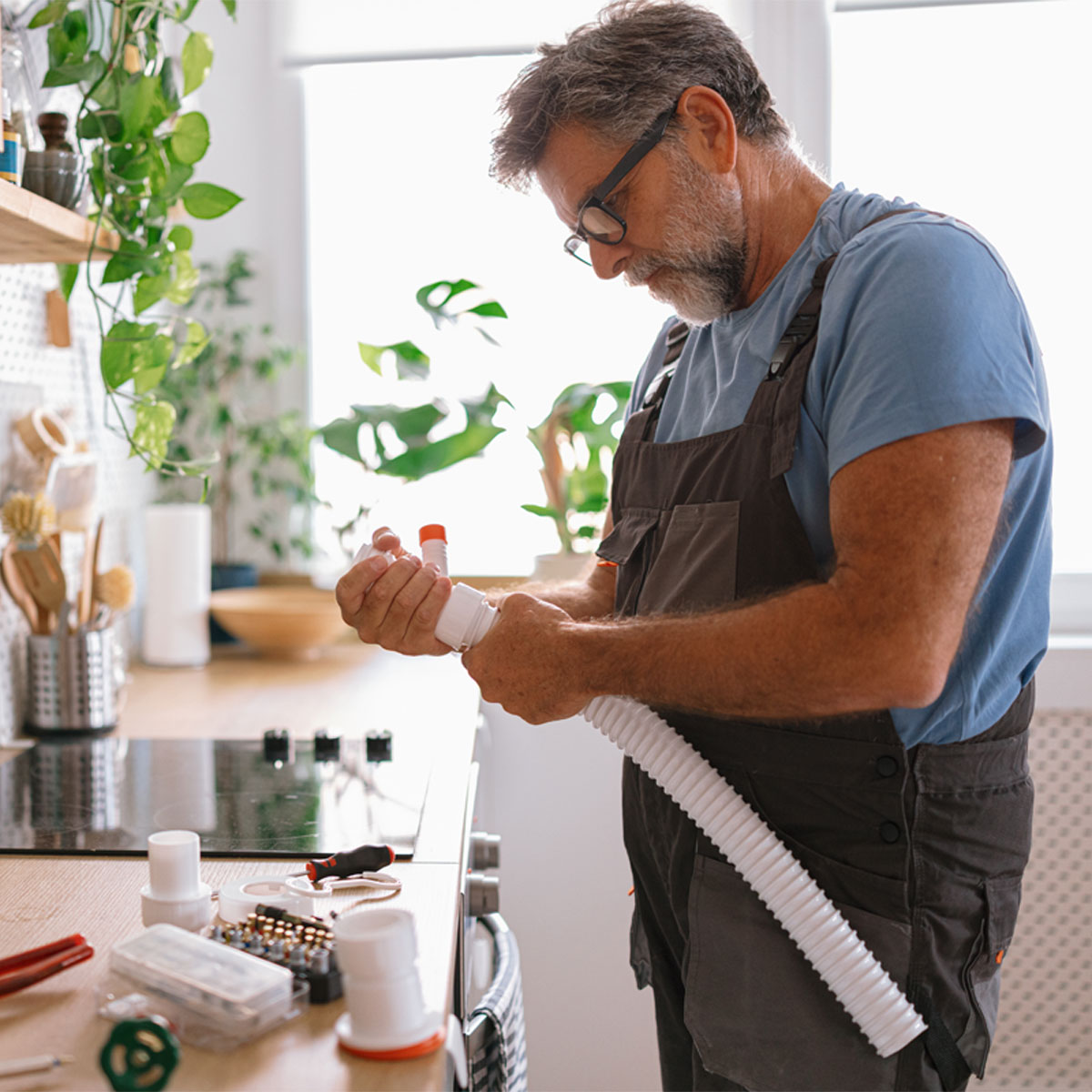 Man repairing washing machine plumbing