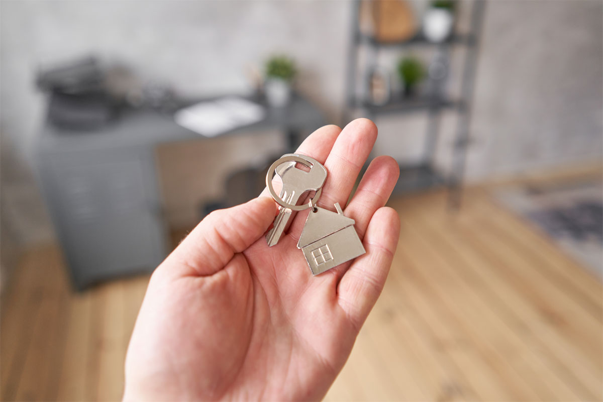 Single silver house key in outstretched palm